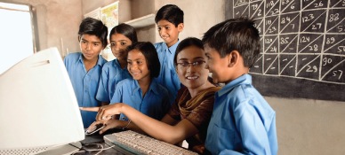 Teacher and students looking at a computer