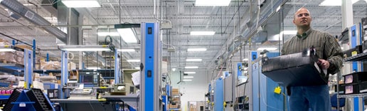 Photo: Man holding equipment on manufacturing floor