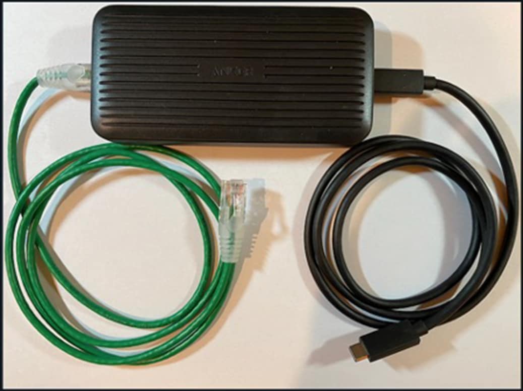 A black box with a green wire next to itDescription automatically generated