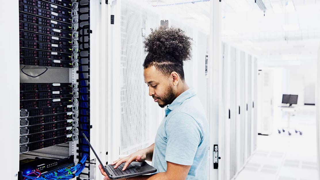 Man standing in front of a server rack.